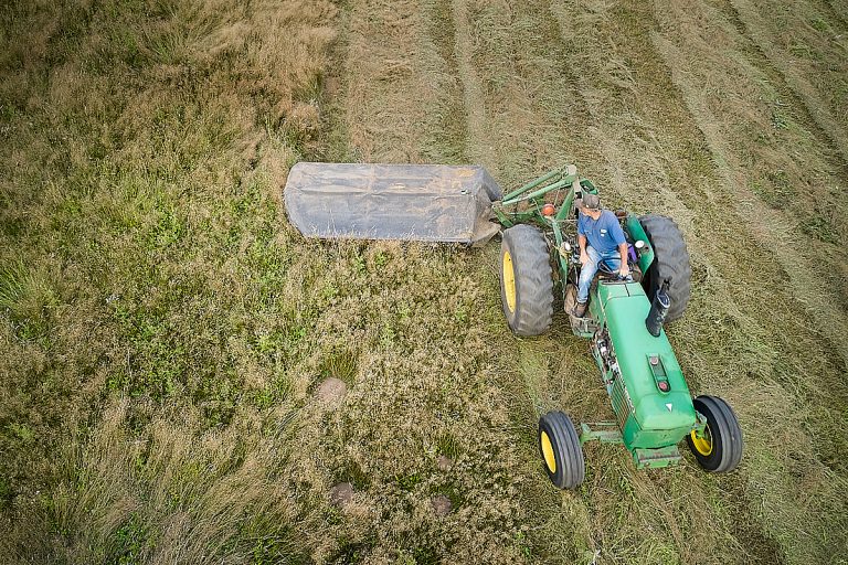 Drone photo of tractor cutting hay.